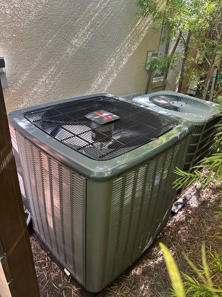 New residential split-system condensing unit installed beside a home